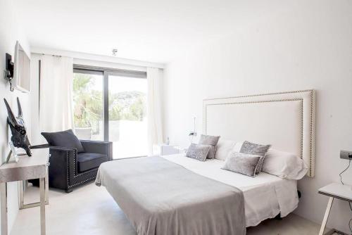 卡拉隆加Villa La Vida的白色卧室配有一张大床和椅子