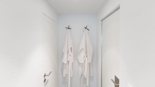 巴蒂斯côté verger B&B的浴室的墙壁上挂着白色毛巾