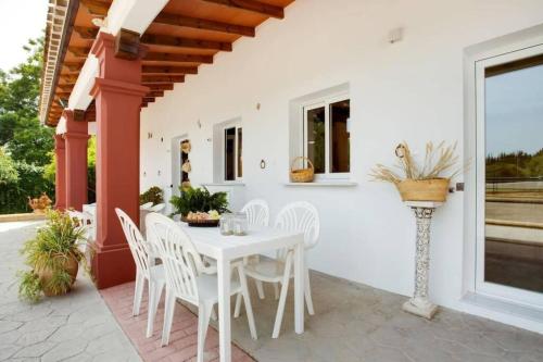 米哈斯科斯塔Finca El Altabacar - Casa Rural - Playa的庭院里的白色桌椅