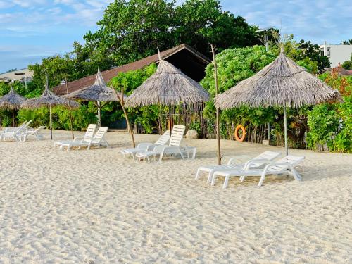古莉ilaa Beach Maldives的海滩上的一组椅子和遮阳伞