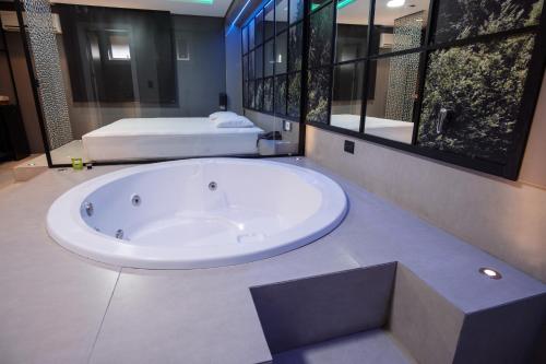 本图贡萨尔维斯Motel Della Montagna (Adult Only)的带2张床的浴室设有大浴缸