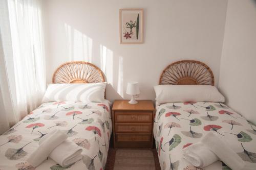 莱斯卡瑟斯-达尔卡纳Duplex a 50m de la playa de les Cases d'Alcanar的卧室内两张并排的床