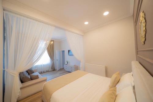 奥拉迪亚BlueSky Ultra-Central Premium Apartment的白色卧室配有床和沙发