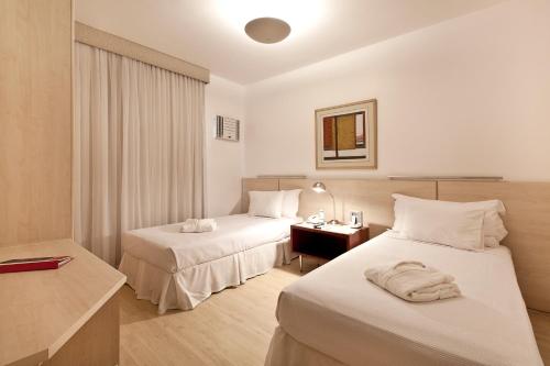 贝洛奥里藏特Promenade Pancetti Belo Horizonte的酒店客房配有两张床和一张书桌