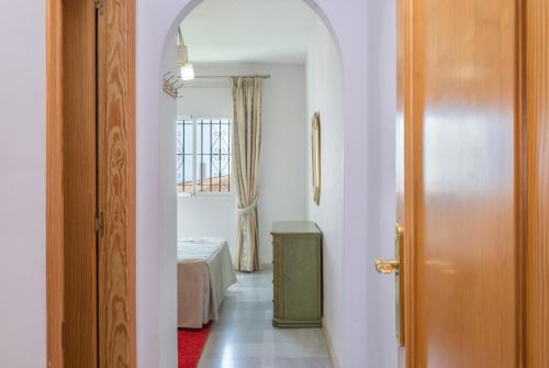 米哈斯科斯塔Apartment Miraflores的走廊上设有一张床和一扇门的房间