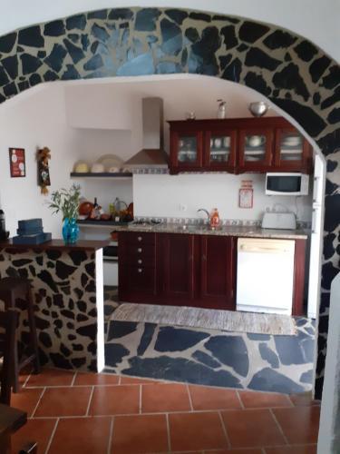 阿维斯Casa do Montinho的厨房配有木制橱柜和石墙