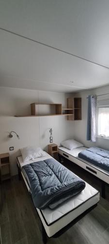 波讷地区圣朱利安Mobilhome 2 ch,1 salon 40m2 de Charme dans camping ***的一间卧室设有两张床和窗户。