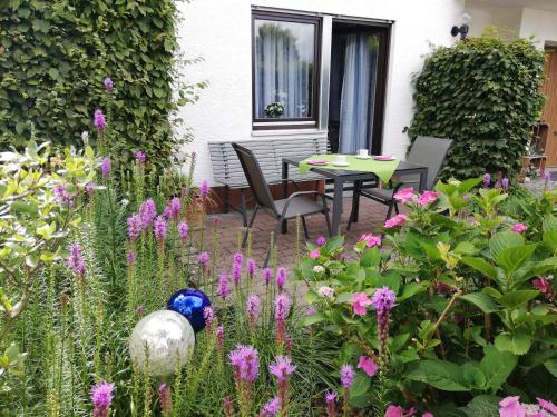 米歇尔施塔特Annettes Ferienwohnung的花园配有桌椅和鲜花