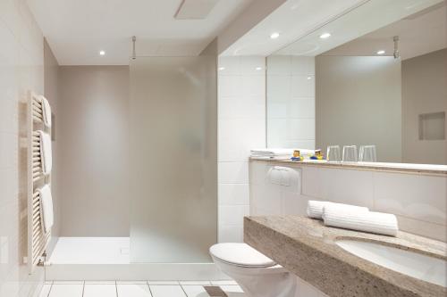汉堡汉堡港酒店的一间带卫生间、水槽和镜子的浴室