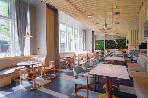 晋江晋江温德姆花园酒店的餐厅设有桌椅和窗户。