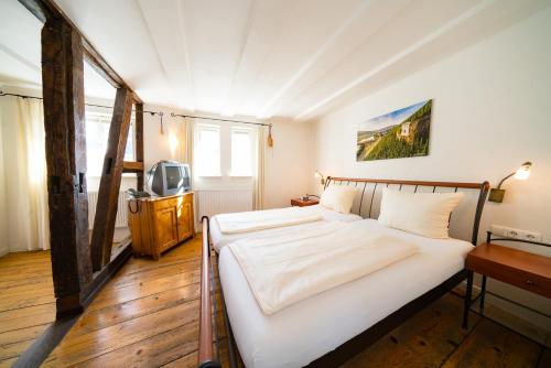 策尔廷根-拉蒂希Gästehaus Ratsschänke的一间卧室配有两张床和电视。