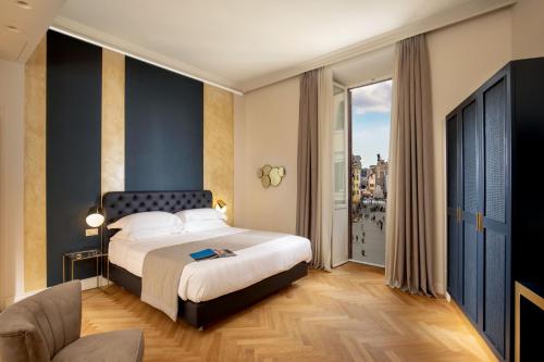 罗马Spagna Luxury Rooms的酒店客房设有一张床和一个大窗户