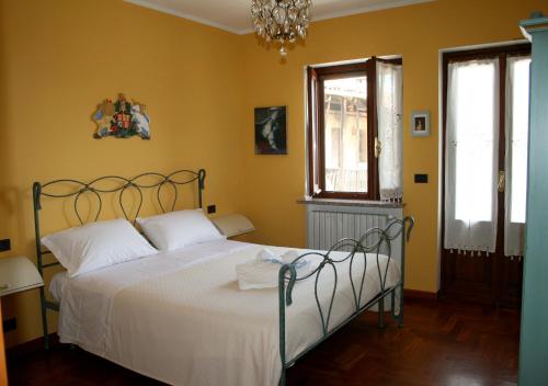 MagnanoLa Robinera的一间卧室配有一张带白色床单和黄色墙壁的床。