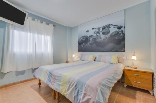 坎德拉里亚Apartamento Deluxe的一间带大床和电视的卧室