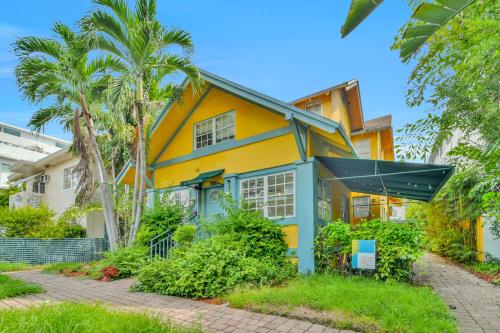 迈阿密海滩Sunflower Boutique Hotel Apartments的棕榈树的黄色和蓝色房子