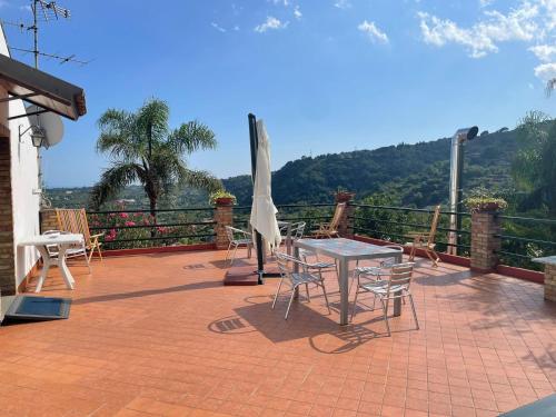加里Il noceto dell'Etna的庭院配有桌椅和遮阳伞。