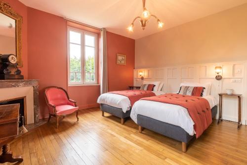 里摩日Edouard & Louise - Chambres d'hôtes的配有红色墙壁和壁炉的客房内的两张床