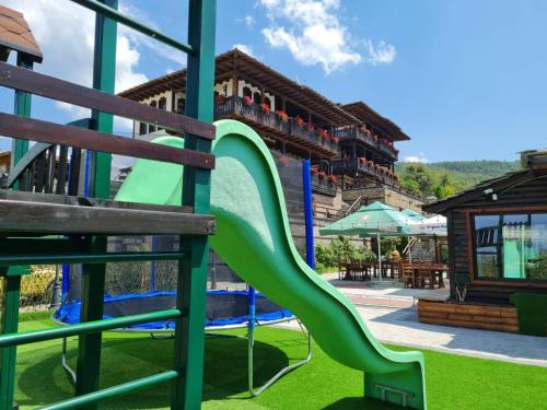 莱什顿赖斯登斯基莱酒店的度假村内带绿色滑梯的游乐场