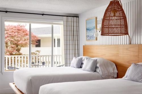 南雅茅斯Bluebird Parker Beach Lodge的卧室设有两张床,享有门廊的景色