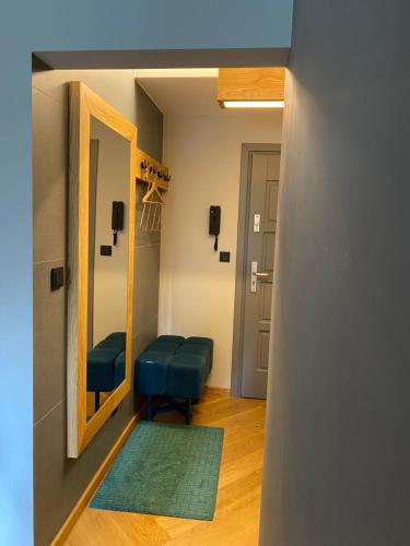 博赫尼亚Apartament Krakowska的小房间设有镜子和蓝色凳子