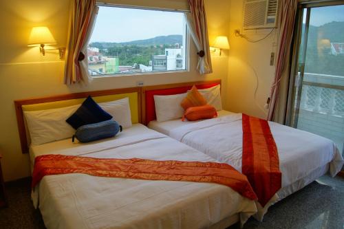 垦丁大街垦丁福乐渡假饭店 的配有窗户的酒店客房内的两张床
