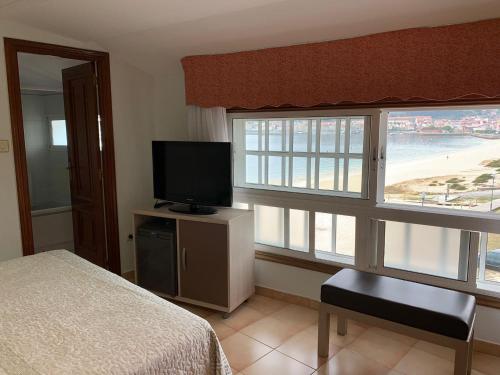 坎加斯德穆拉索普拉亚酒店的卧室配有床、电视和窗户。