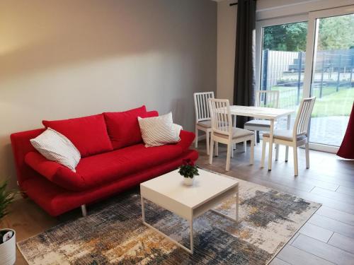 弗希塔Ferienwohnung am Welper-Wald-Vechta-Süd的客厅配有红色的沙发和桌子