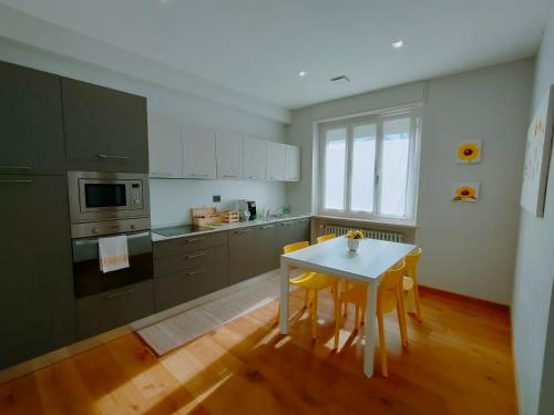 拉莫拉Apartment AL34的厨房配有白色的桌子和黄色的椅子