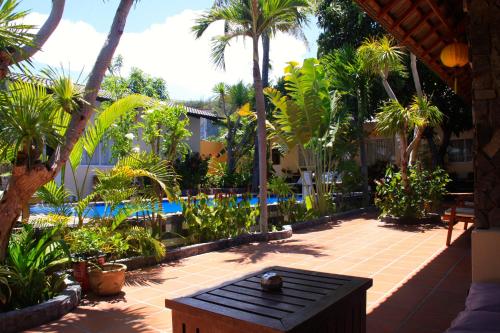 美奈新潮酒店的一个带桌子和棕榈树的庭院和一个游泳池