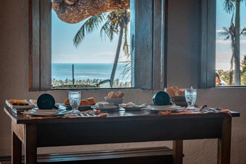 阿拉亚尔达茹达Pousada Anacã的一张桌子,从窗户可欣赏到海滩美景
