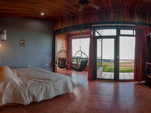 蒙泰韦尔德哥斯达黎加Sunset Vista Lodge,Monteverde,Costa Rica.的卧室配有一张床,卧室配有秋千。