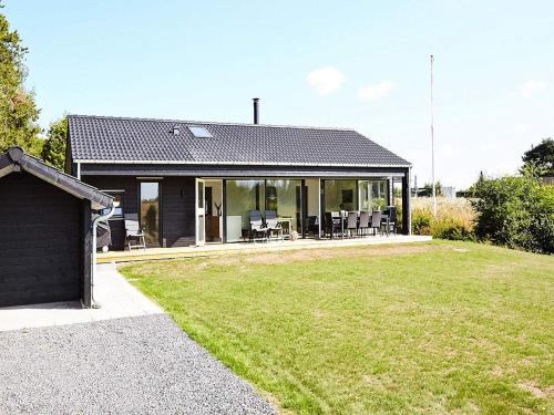 斯劳厄尔瑟8 person holiday home in Slagelse的前面有草坪的黑房子
