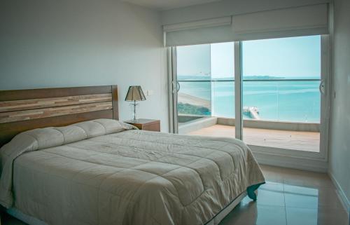 埃斯特角城Alexander Beach Punta del Este的一间卧室配有一张床,享有海景