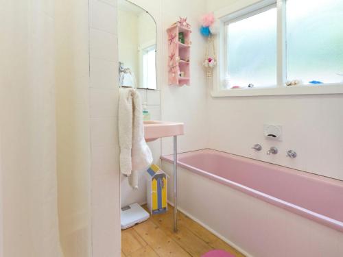 玛莎山Home Sweet Home Mount Martha的粉红色的浴室设有浴缸和水槽