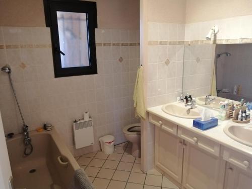 利和米克斯Landes OCEANES - Chambres privées dans villa avec jardin的浴室配有盥洗盆、卫生间和浴缸。