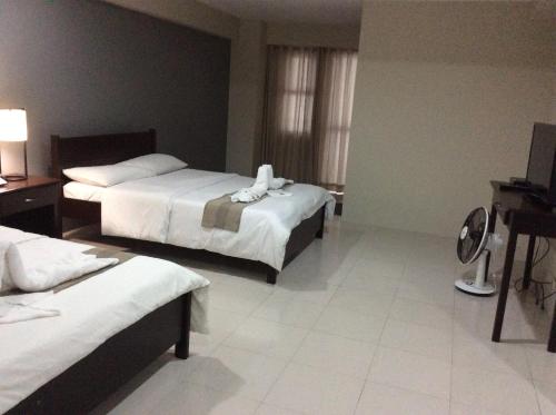 碧瑶Casa Bel的酒店客房设有两张床和电视。