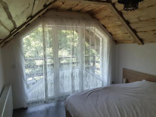 布朗Vila Brandusa的一间卧室设有一张床和一个阳台的窗户。