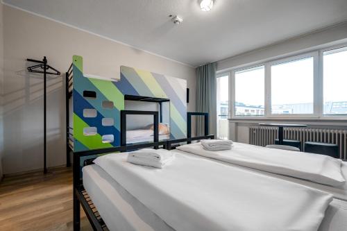 慕尼黑慕尼黑中央火车站A&O经济型连锁酒店 的一间卧室设有两张床,墙上挂着一幅画