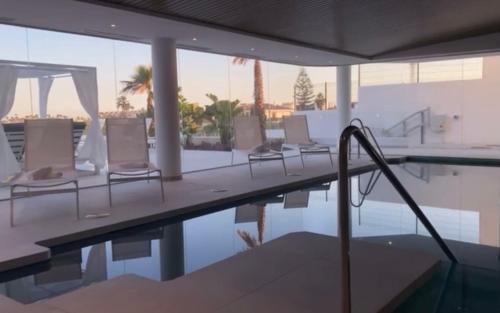 福恩吉罗拉Luxury Penthouse Pedro - The View Fuengirola的游泳池旁的游泳池配有椅子和遮阳伞