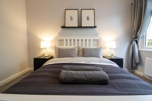 佩恩顿Modern and Stylish Apartment- Short Walk to Beach的一间卧室配有一张大床和两盏灯