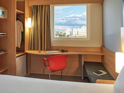 隆德里纳隆德里纳宜必思酒店的客房设有一张带红色椅子的书桌和窗户。