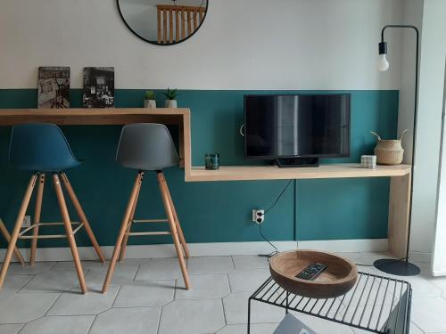 巴涅尔德比戈尔Beau studio avec balcon的客房设有书桌、电视和桌子