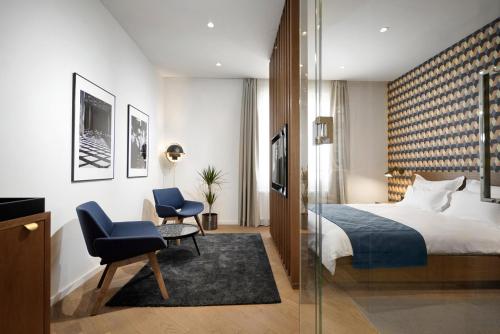 贝尔格莱德Dominic Smart & Luxury Suites - Edition的配有一张床和一把椅子的酒店客房