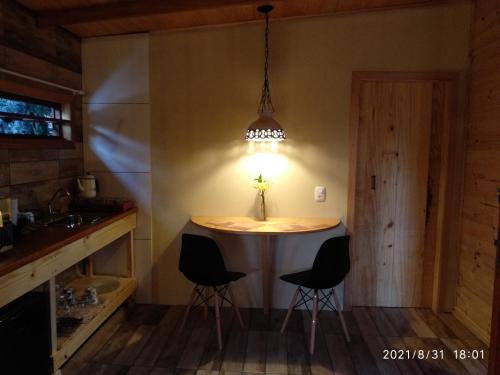 格拉玛多Rancho do Xaxim - Gramado的厨房配有桌椅和灯具