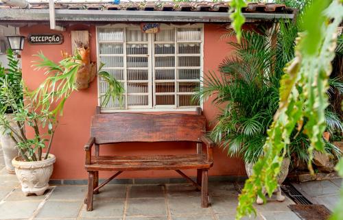 阿瓜斯-迪圣佩德罗Piccola Pousada的旧长凳坐在窗前