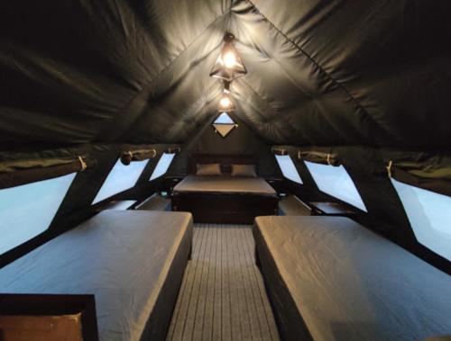 TālKumrat Glamping Resorts的一个小房间,帐篷内有两张床