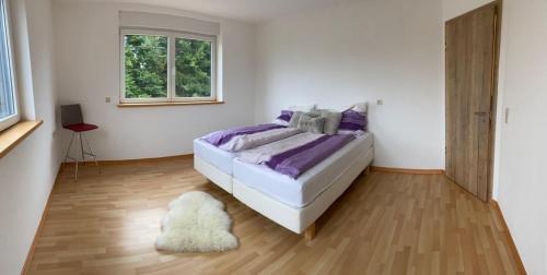 安蓓Residenz Arens的一间卧室配有一张带紫色床单和地毯的床。