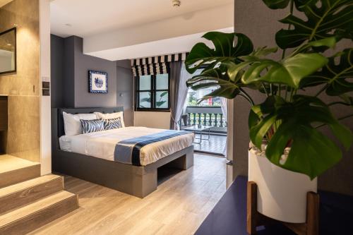 新加坡Heritage Collection on Boat Quay - Quayside Wing - A Digital Hotel的一间卧室配有一张床和盆栽植物