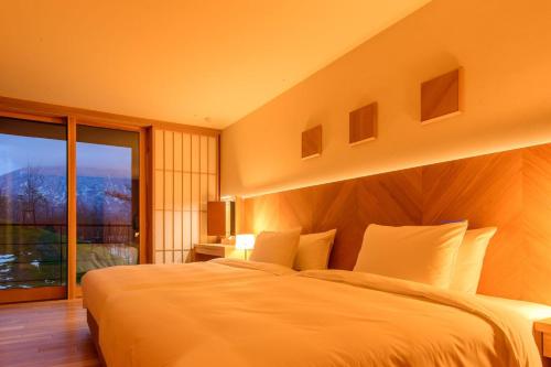 俱知安町NISEKO Inn of Youtei Raku Suisan的一间卧室设有一张大床和一个大窗户