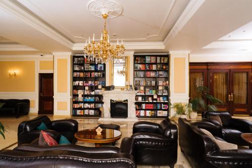 圣彼得堡艾米瑞达格兰德酒店的客厅配有皮革家具和壁炉